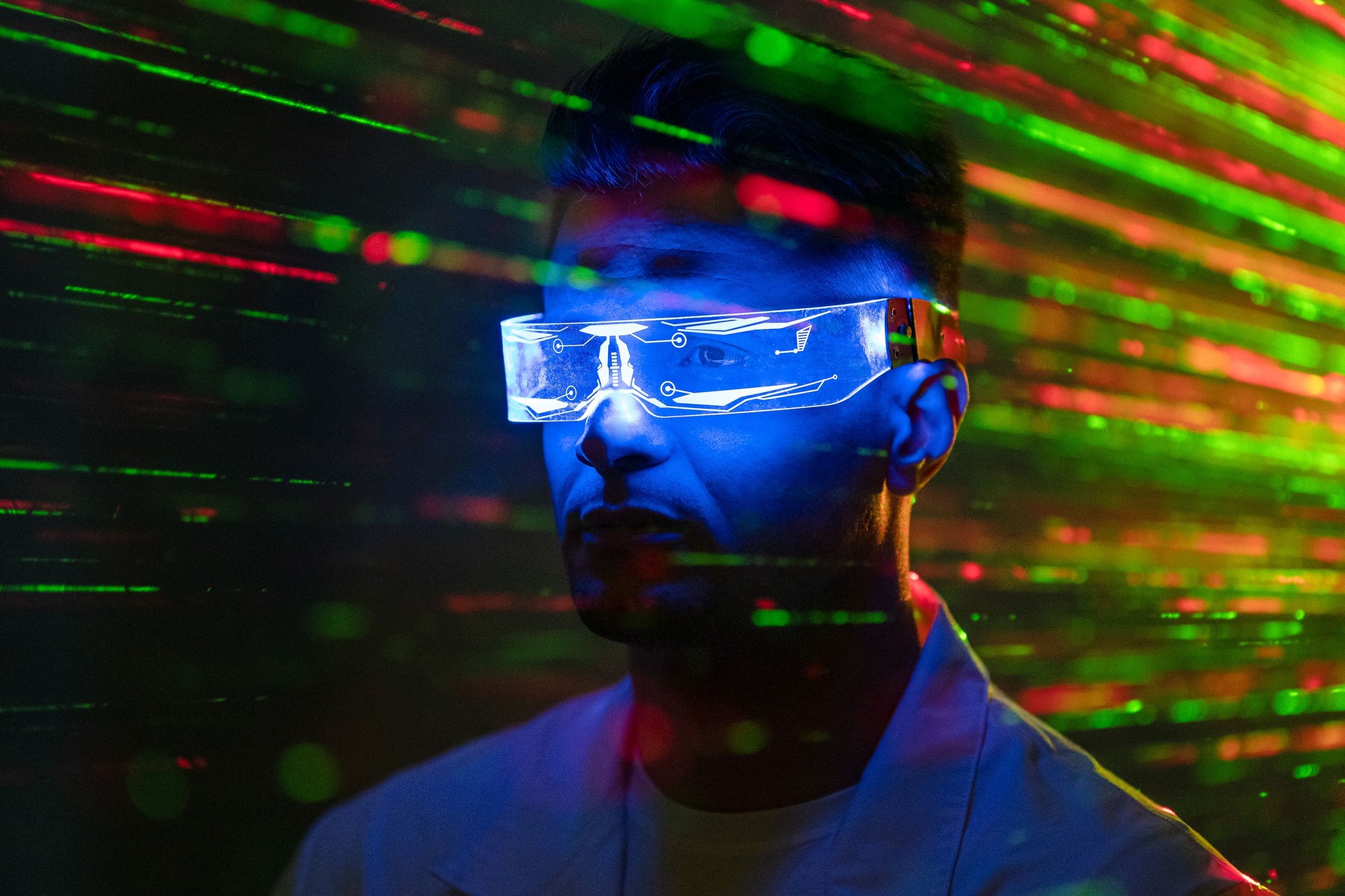 The handsome man in futuristic glasses standing on a laser rays background